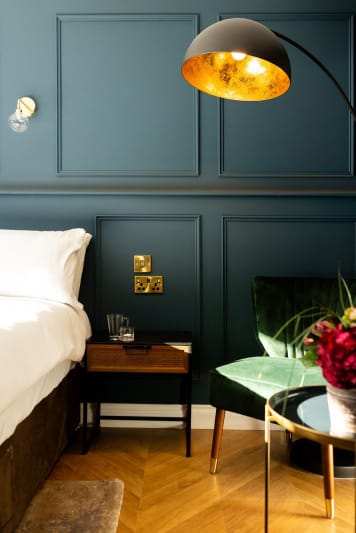 A neatly made bed with a lamp beside it