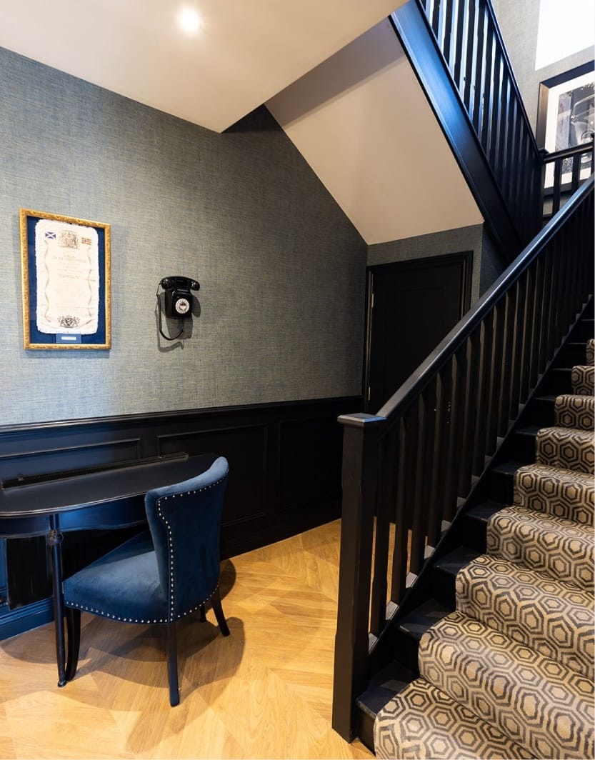 A black staircase leads to a blue chair